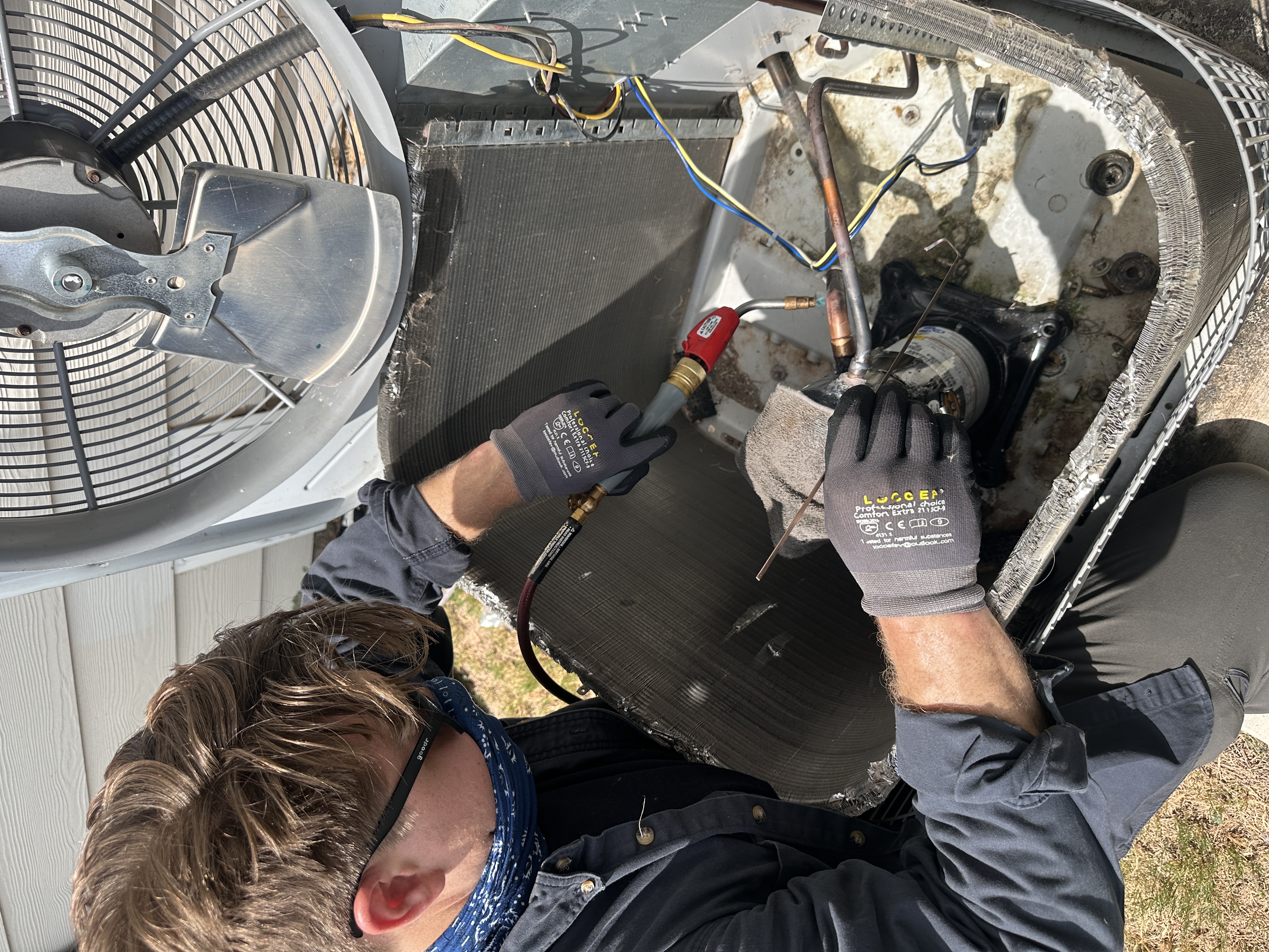 HVAC technician servicing an air conditioning system in the Austin area